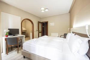 sypialnia z łóżkiem i biurkiem z telewizorem w obiekcie Hotel Il Portico w mieście Cannobio