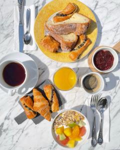 a table with a plate of bread and a bowl of fruit at Hôtel L'Ours De Mutzig in Mutzig