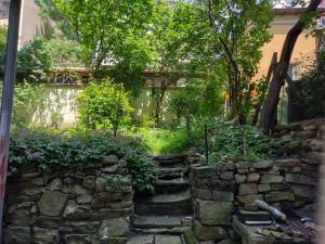 einen Garten mit einer Steinmauer und einer Treppe in der Unterkunft Cozy Spacious Apt with Garden near Parking Fast Wifi - A HOME Away from Home in Sofia