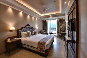 una camera d'albergo con letto e TV di The Fern Shelter Resort Palghar a Manor