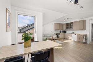 オスロにあるUrban Panorama - New, Central & Private Terraceのオープンキッチン、リビングルーム(木製テーブル付)