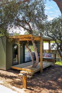 una casa en el árbol con un banco delante de ella en wecamp Santa Cristina, en Santa Cristina d'Aro