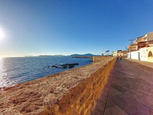 a sidewalk next to a body of water at Protea House in Alghero