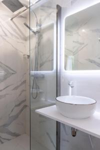 a white bathroom with a sink and a shower at Hôtel d'Angleterre Rouen Centre Gare in Rouen