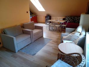 sala de estar con sofá, sillas y mesa en Apartament Wolin nad wodą koło Miedzyzdrojów en Wolin