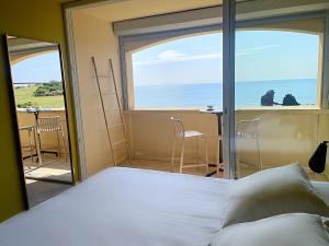 a bedroom with a bed and a view of the ocean at Hôtel La Grande Conque in Cap d'Agde