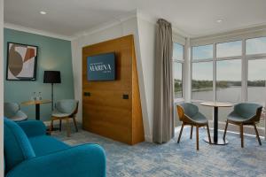 una sala de espera con sillas, TV y ventanas en Waterford Marina Hotel en Waterford