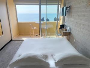 a bed in a room with a view of the ocean at Hôtel La Grande Conque in Cap d'Agde +56 photos