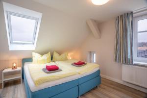 een slaapkamer met een bed met twee rode kussens erop bij Alte Liebe Zinnowitz in Zinnowitz