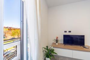a living room with a flat screen tv next to a window at KHL APARTMENTS - SanSiro, Milano in Milan