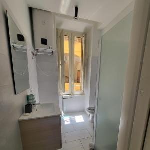 biała łazienka z umywalką i oknem w obiekcie Vulcania Rooms w mieście Napoli