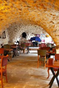 Mons Masius Boutique Hotel Cafe في مِديات: غرفة طعام مع طاولات وكراسي في جدار حجري