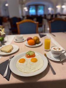 einen Tisch mit einem Teller Eier und Obst darauf. in der Unterkunft Fonte Hotel in Győr