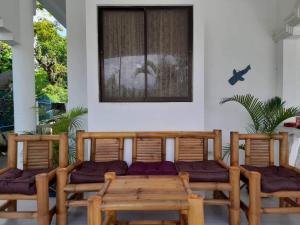 a room with three wooden chairs and a window at Beth's Villa in Moalboal