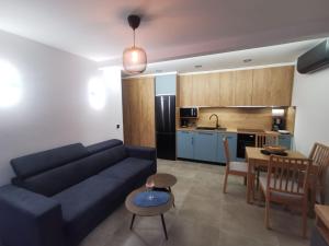 a living room with a blue couch and a kitchen at RITUAL Apartment - 20m from the sea in Lovran