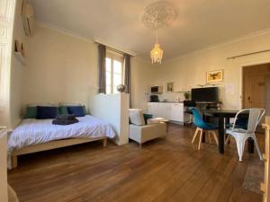 1 dormitorio con cama, escritorio y mesa en #Le Maitre du Navire - Grand Studio - Hyper centre, en Brive-la-Gaillarde