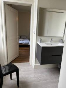 baño con lavabo, espejo y cama en #Le Maitre du Navire - Grand Studio - Hyper centre en Brive-la-Gaillarde