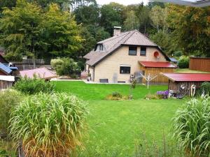 una casa con un patio con césped verde en Ferienwohnung am Wald, en Unterlüß