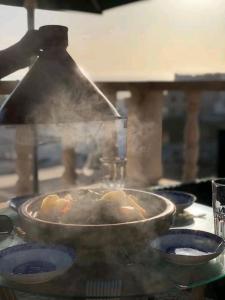 a person cooking food in a pan on a stove at appartement Ocean in Tamraght Ouzdar