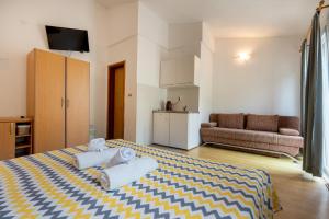 a bedroom with a bed and a couch in it at Apartments IN in Neum