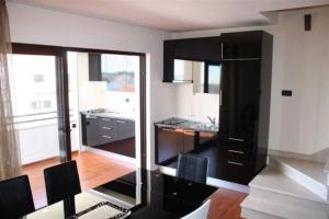 eine Küche mit schwarzen Schränken und einem großen Fenster in der Unterkunft Villa Bruna in Trogir