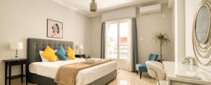 Schlafzimmer mit einem Bett mit gelben und blauen Kissen in der Unterkunft Alopekis in Athen