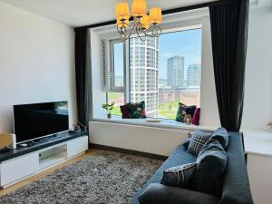 salon z kanapą i dużym oknem w obiekcie Apartments09 in new building with free parking Panorama city - amazing view close to Old town w Bratysławie