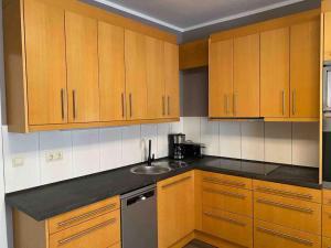 a kitchen with wooden cabinets and a sink at Am Bahnhof in Bersenbrück