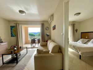 Una sala de estar con un sofá, una cama y una mesa. en Appartement Résidence Salin Bay, en Porto Vecchio 6 fotos más
