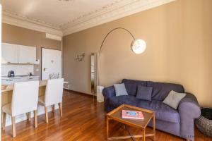 un soggiorno con divano blu e tavolo di Nice Renting - 13 MASSENA - Live A Dream Luxury Loft - Place Massena a Nizza