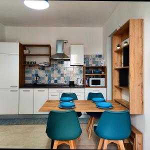 cocina con mesa de madera y sillas azules en Marzamemi - Appartamento Girasole al Borgo 84, en Marzamemi