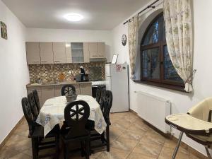 a kitchen and dining room with a table and chairs at Casa meșterului in Sohodol