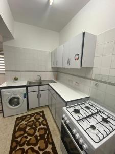 a kitchen with a stove and a washing machine at Musty's Home in Famagusta