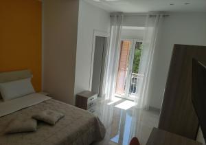 um quarto branco com uma cama e uma janela em Locazione turistica Totaro em Vico del Gargano