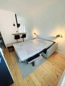 uma cama de hospital num quarto com piso de madeira em Charmant studio en centre-ville em Saint-Dié-des-Vosges