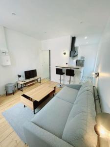 ein Wohnzimmer mit einem blauen Sofa und einem Tisch in der Unterkunft Charmant studio en centre-ville in Saint Die