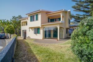 une grande maison avec une clôture devant elle dans l'établissement Jiri Villa With Swimming Pool by MRH, à Ponta do Sol