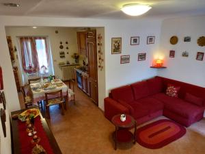 sala de estar con sofá rojo y mesa en La casa dei Nonni, en Treiso