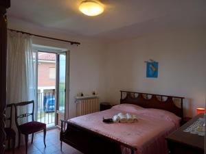 a bedroom with a bed and a table and a window at La casa dei Nonni in Treiso