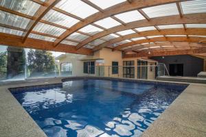 an indoor swimming pool with a glass ceiling at Jiri Villa With Swimming Pool by MRH in Ponta do Sol