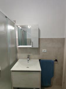 y baño con lavabo y espejo. en Marzamemi - Appartamento Girasole al Borgo 84, en Marzamemi