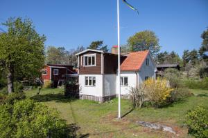 una pequeña casa en un patio con un poste en Lovely holiday home with a sea view en Oskarshamn