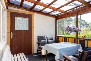 porche con mesa, sillas y ventana en Lovely holiday home with a sea view, en Oskarshamn