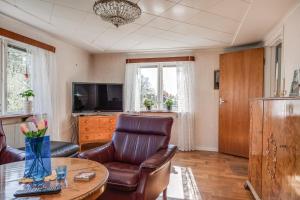 a living room with a couch and a table and a tv at Lovely holiday home with a sea view in Oskarshamn