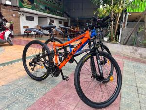 an orange bike is parked on a sidewalk at Por Chey Hostel in Battambang