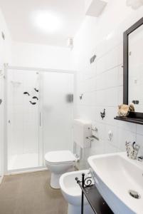 a white bathroom with a toilet and a sink at Villa Pizzini Mottarone - Restaurant and rooms in Stresa