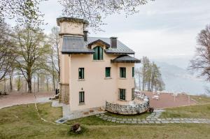 Villa Pizzini Mottarone - Restaurant and rooms في ستريزا: منزل على قمة تل