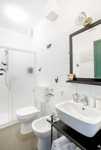 bagno bianco con lavandino e servizi igienici di Villa Pizzini Mottarone - Restaurant and rooms a Stresa
