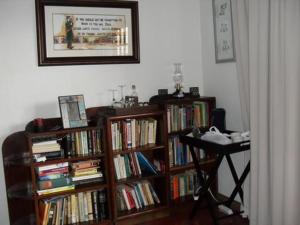 a room with two book shelves filled with books at Aspen Guest House in Clarens