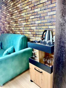a green couch in a room with a brick wall at Old Tree Home & Restaurant in Oświęcim